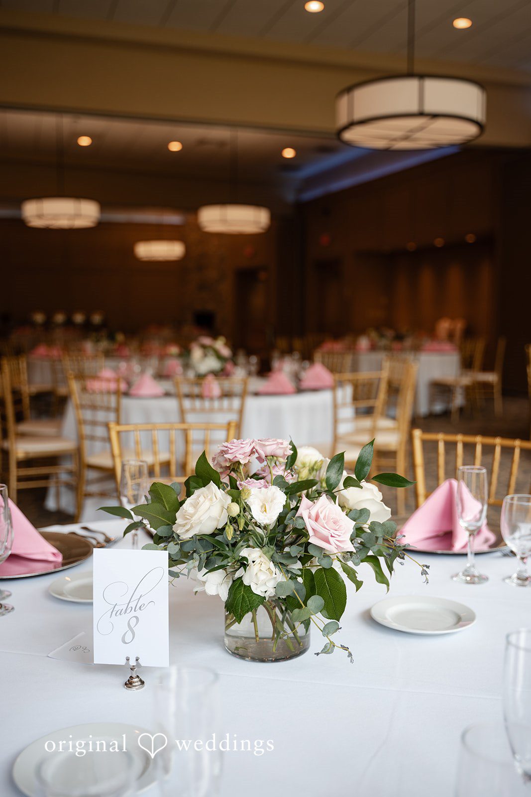 Aislyn + Alex Round reception tables set with white linens, glassware, and floral centerpieces.