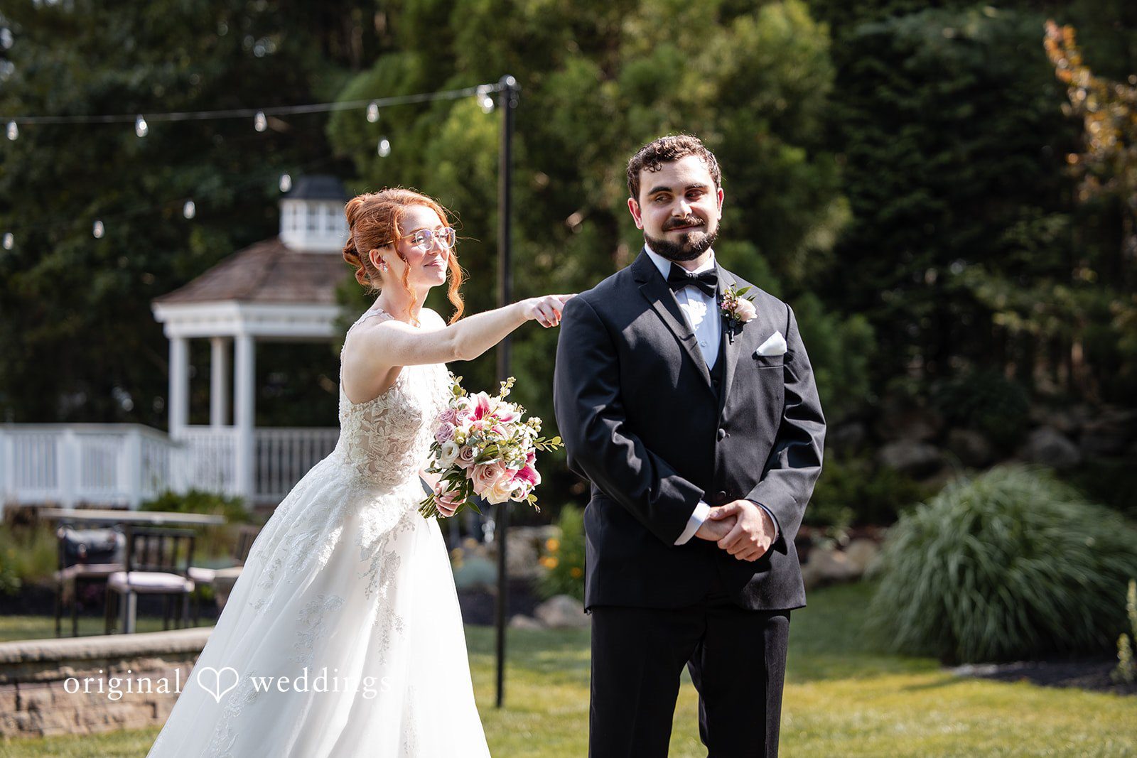 Aislyn + Alex Bride and groom sharing a playful moment while posing together on a lawn.