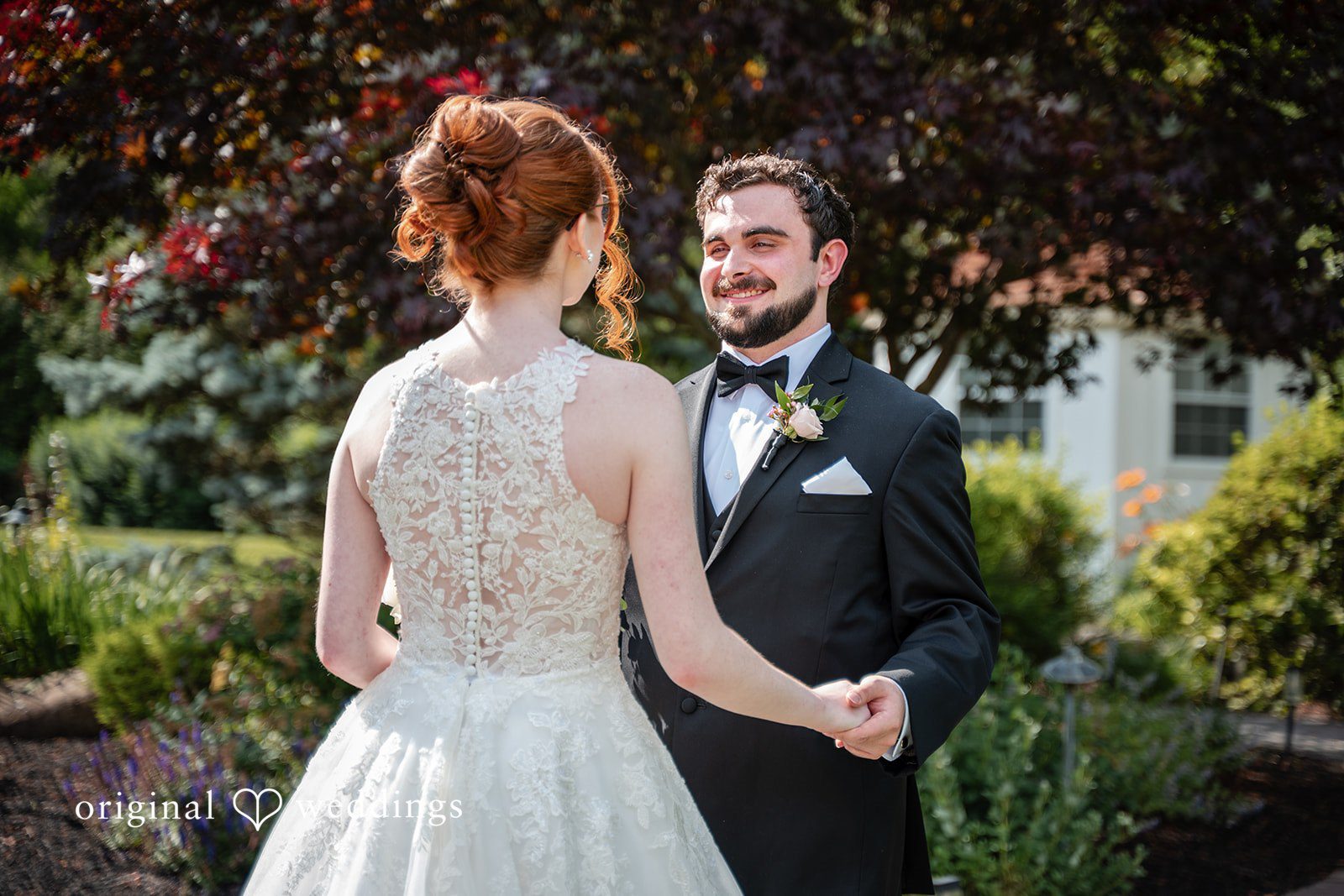 Aislyn + Alex Newlyweds smiling at one another while posing together near green trees.