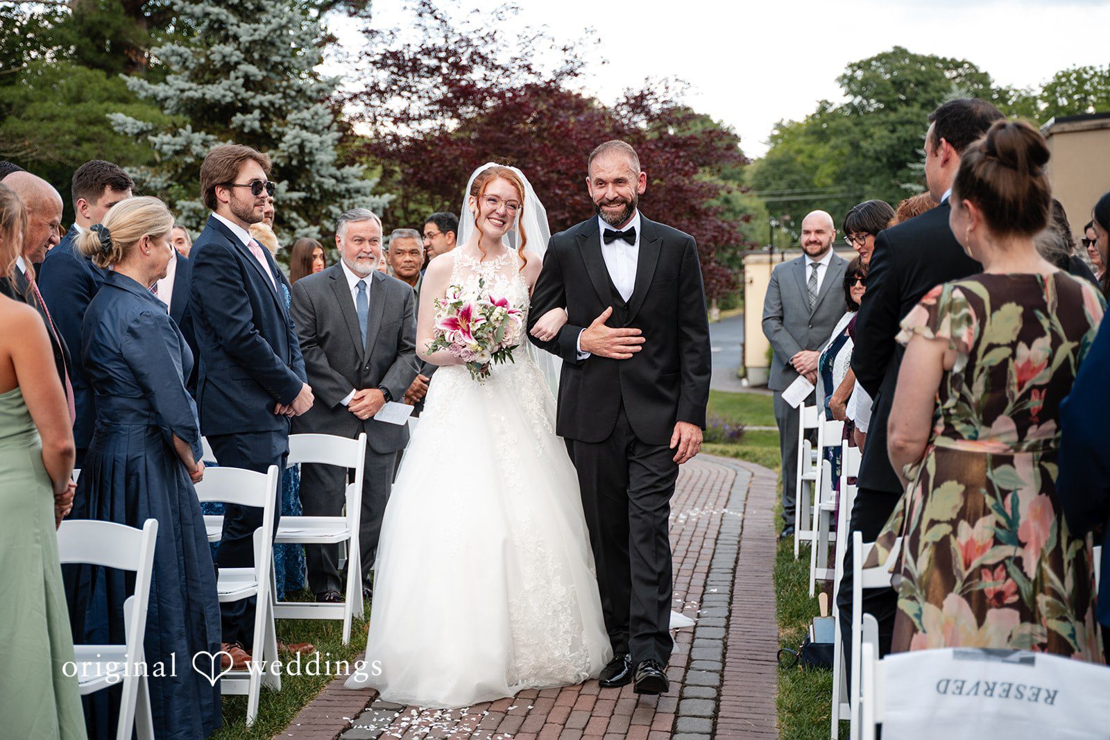 Aislyn + Alex Bride walking down the aisle with a man at Miraval Gardens.