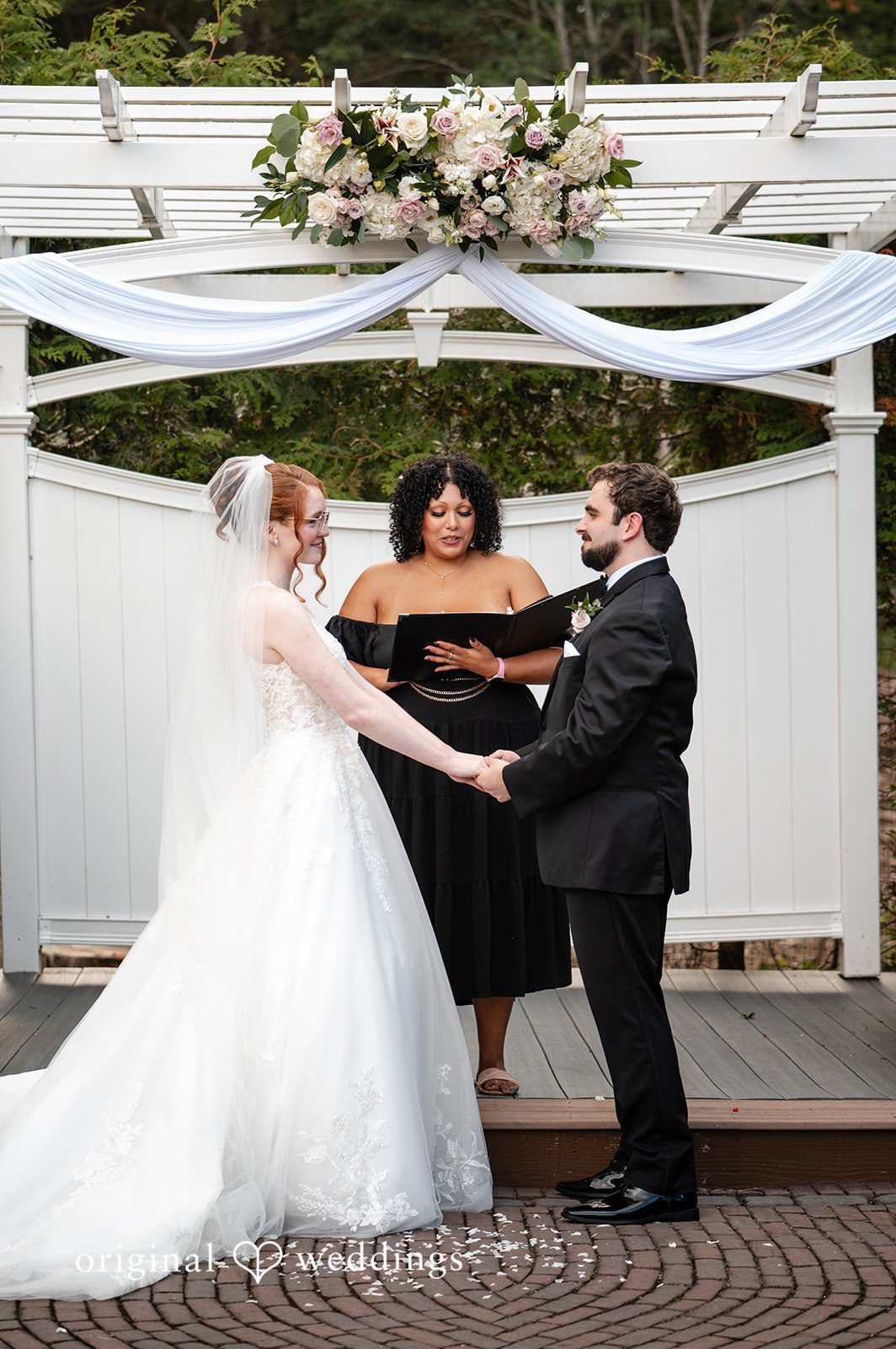 Aislyn + Alex Bride and groom holding hands at the altar during their wedding ceremony.