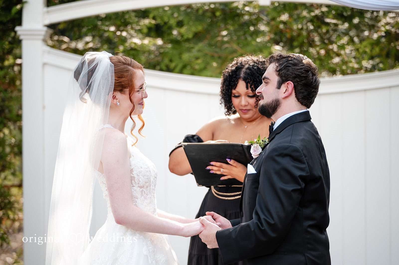 Aislyn + Alex Bride and groom facing each other while the officiant reads from a booklet.