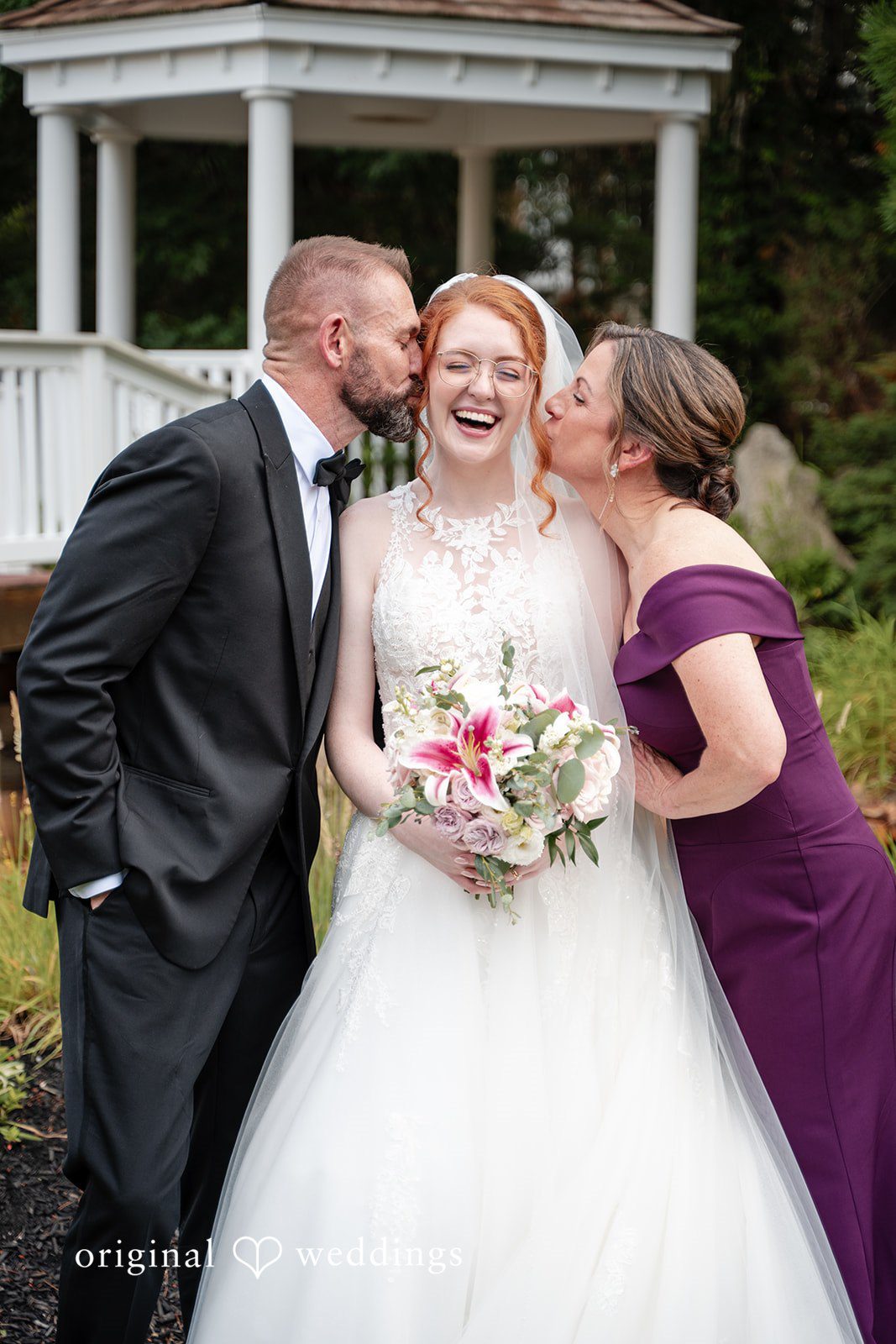 Aislyn + Alex Man and a women in a purple dress kissing the bride on her cheeks.