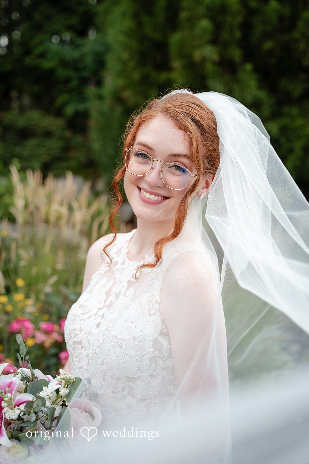 Aislyn + Alex Portrait of a smiling bride wearing a sheer veil.