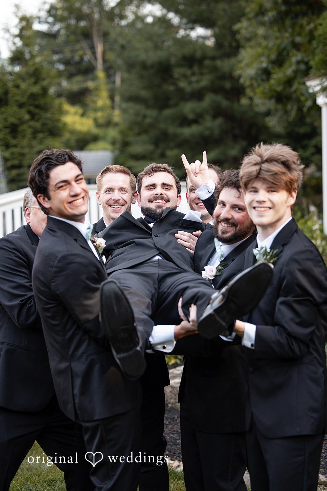 Aislyn + Alex Groom standing with his groomsmen dressed in matching black suits.