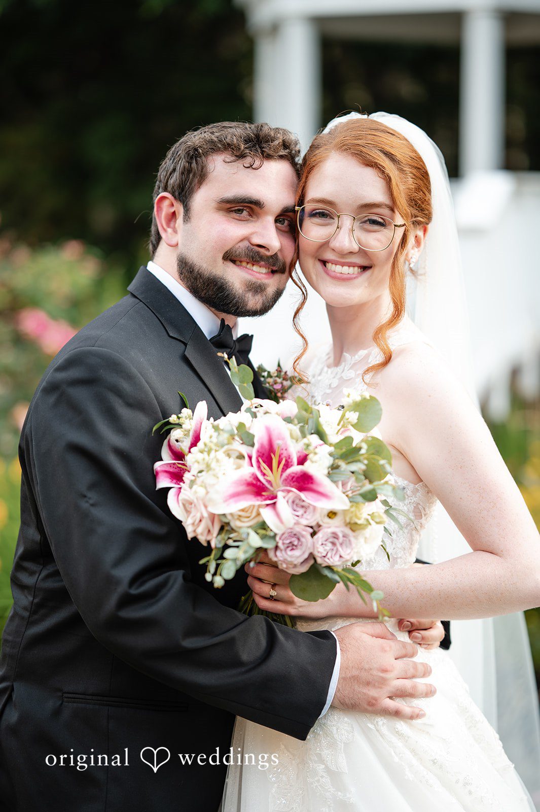 Aislyn + Alex Close-up portrait of the groom embracing the smiling redhead bride holding her bouquet.