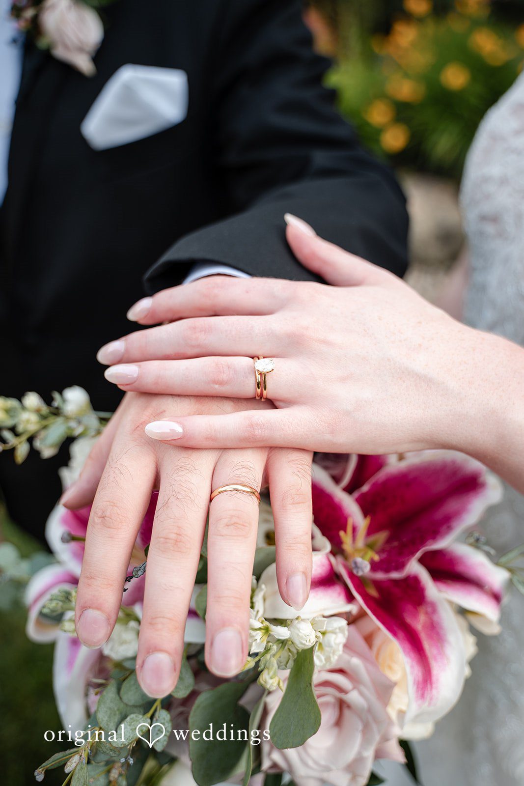 Aislyn + Alex Close-up shot of the bride and groom showing off their wedding rings over a bouquet.