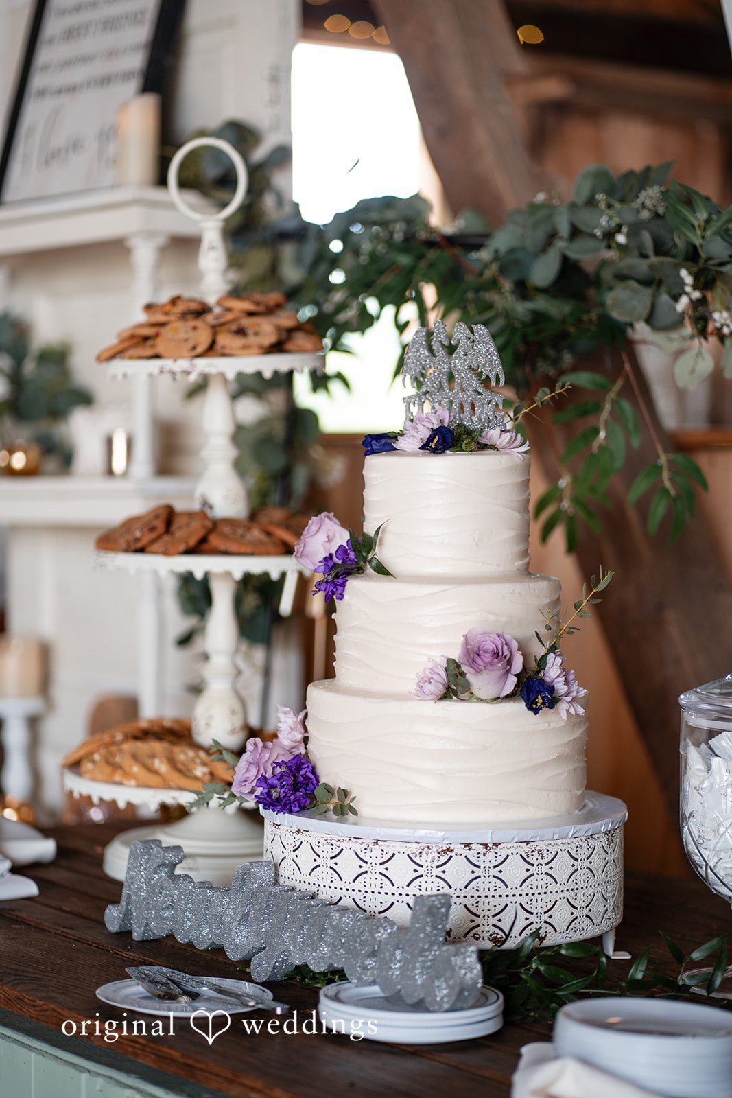 David + Courtney An all-white wedding cake adorned with delicate florals