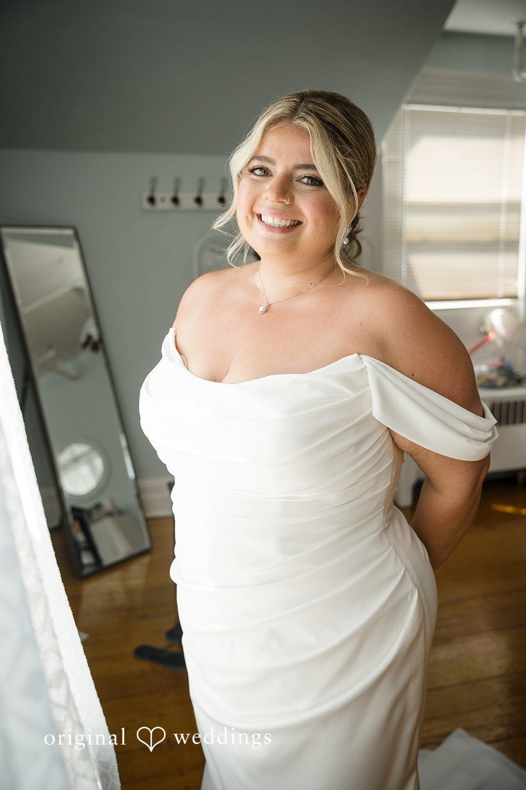 Ashley + Jonathan Smiling bride in an off-the-shoulder wedding gown.