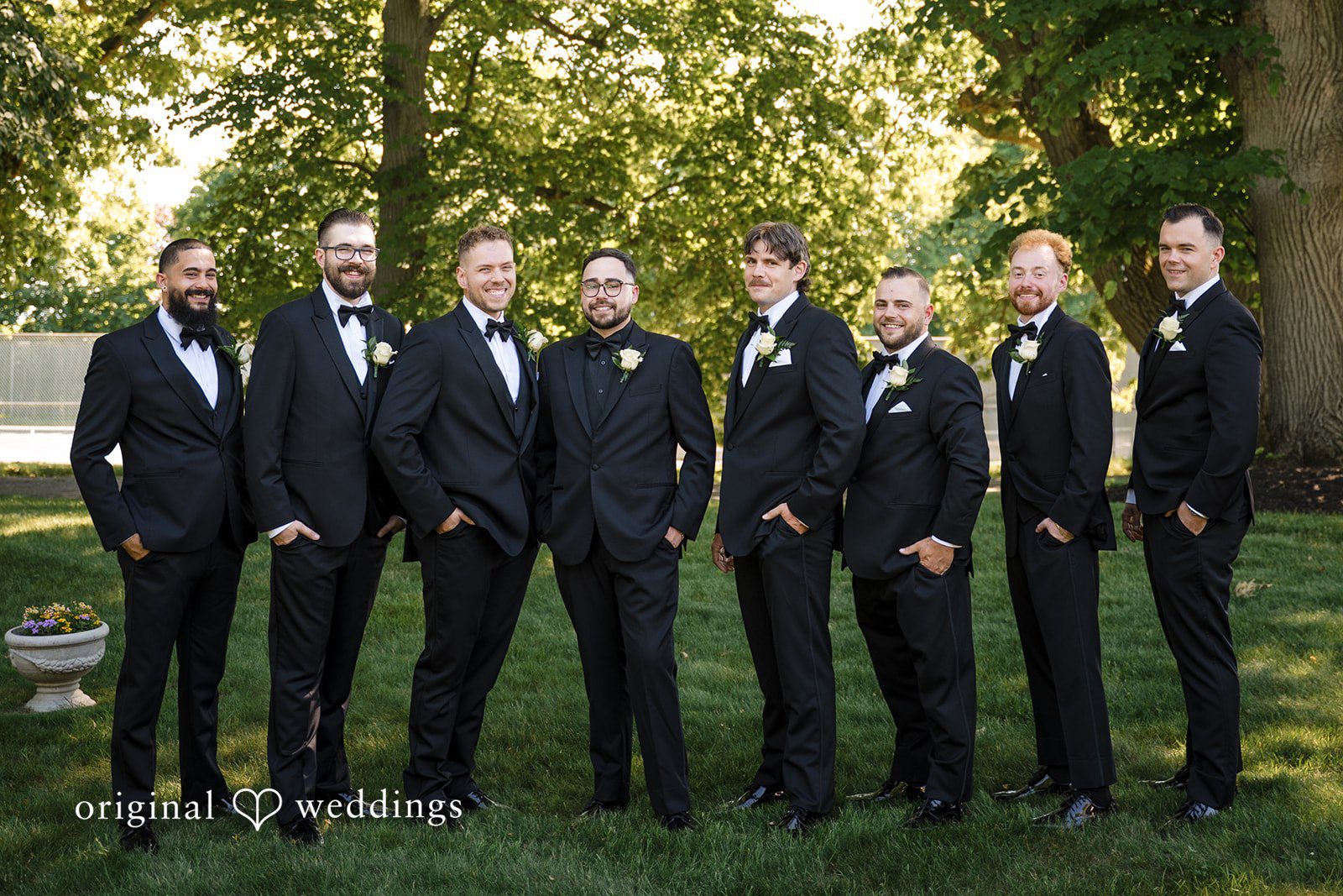 Ashley + Jonathan Groom and his groomsmen standing side by side in matching black suits.