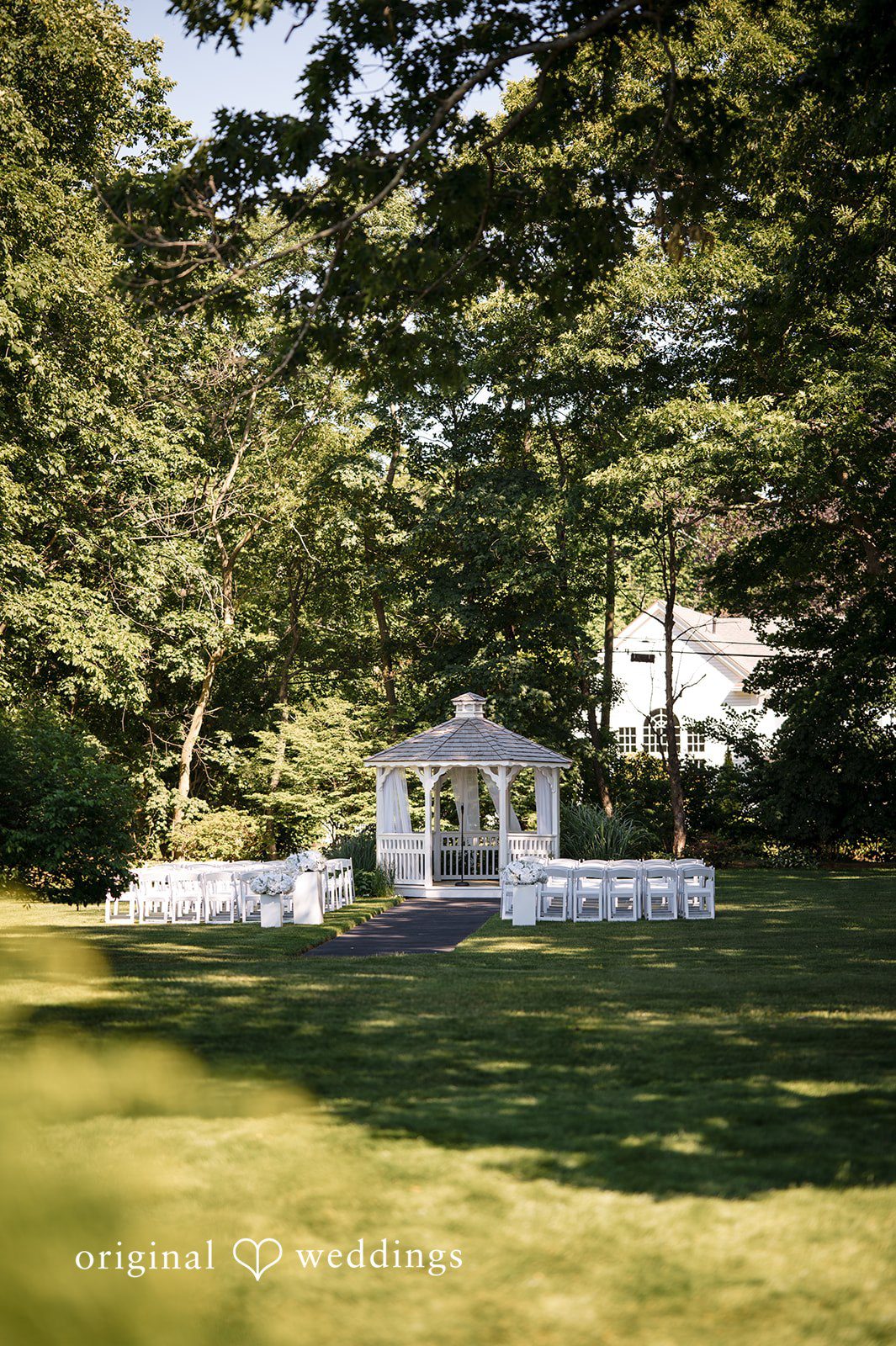 Ashley + Jonathan View of an empty wedding ceremony setup on a sunny grass lawn.