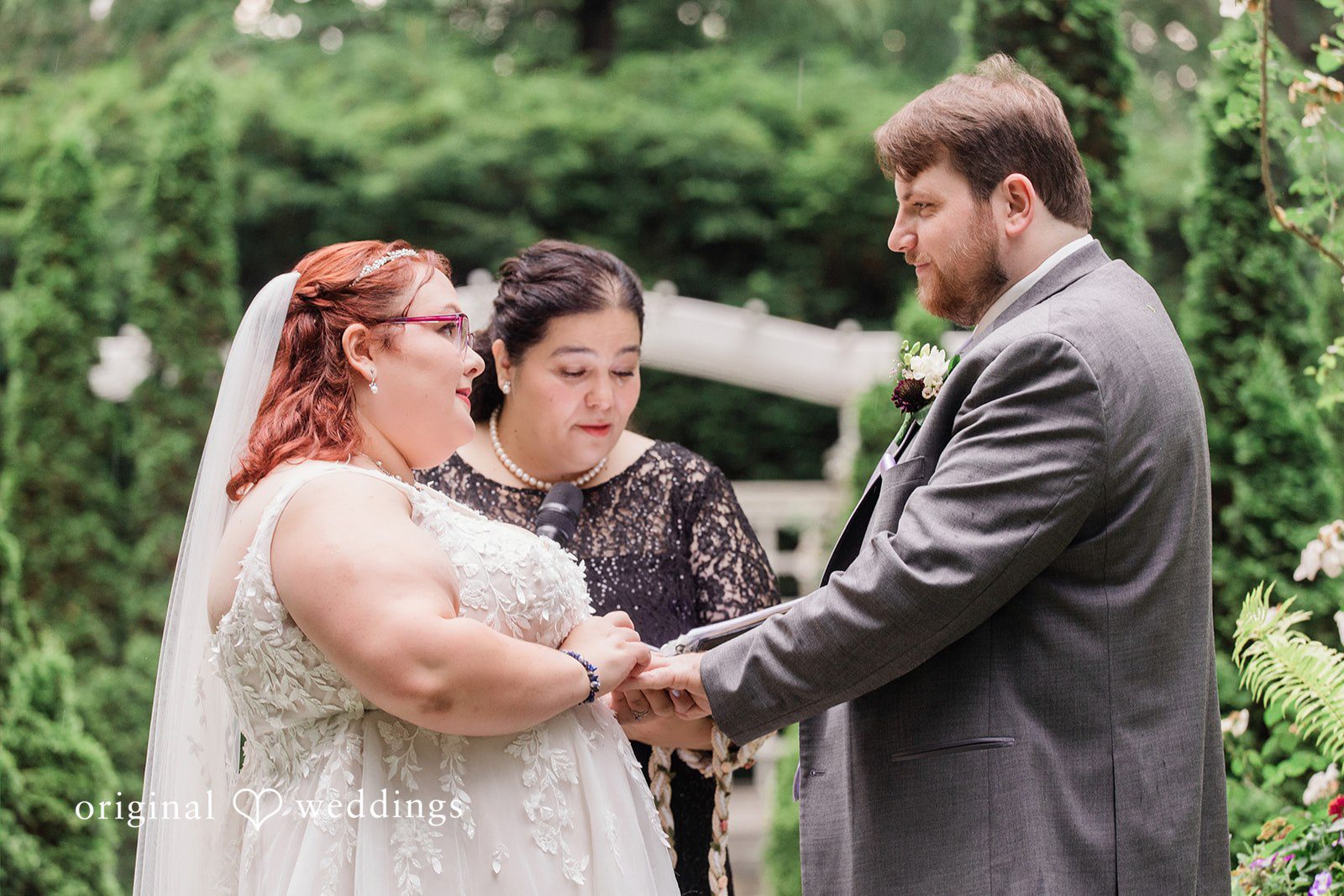 Grace + Nicholas A close-up of a bride and groom exchanging vows with an officiant.