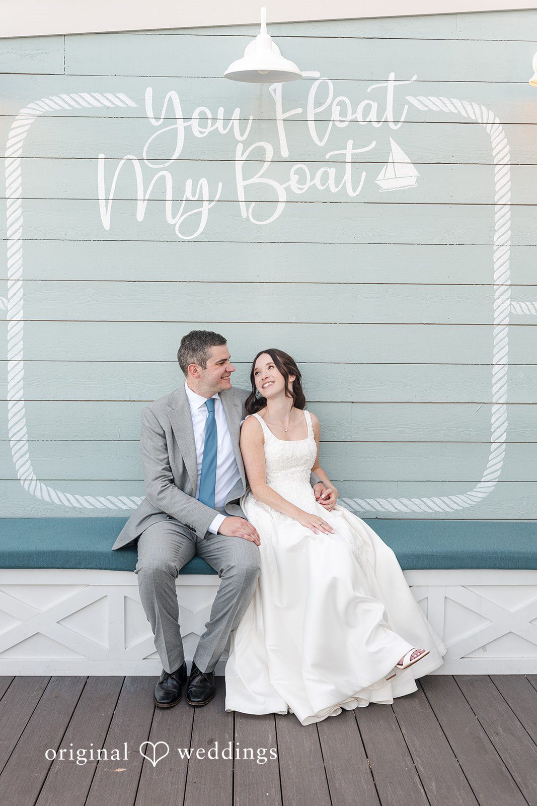 Kerri + David Newlyweds sharing smiles beneath the coastal-inspired wall at Oceanview of Nahant