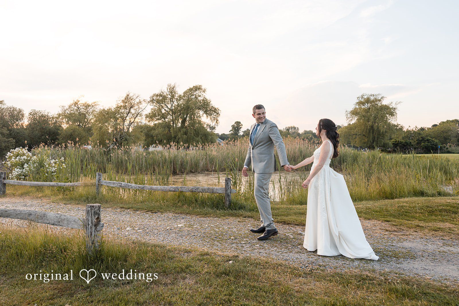 Kerri + David Bride and groom holding hands during a sunset stroll at Oceanview of Nahant captured by Boston Wedding Photographers from Original Weddings.