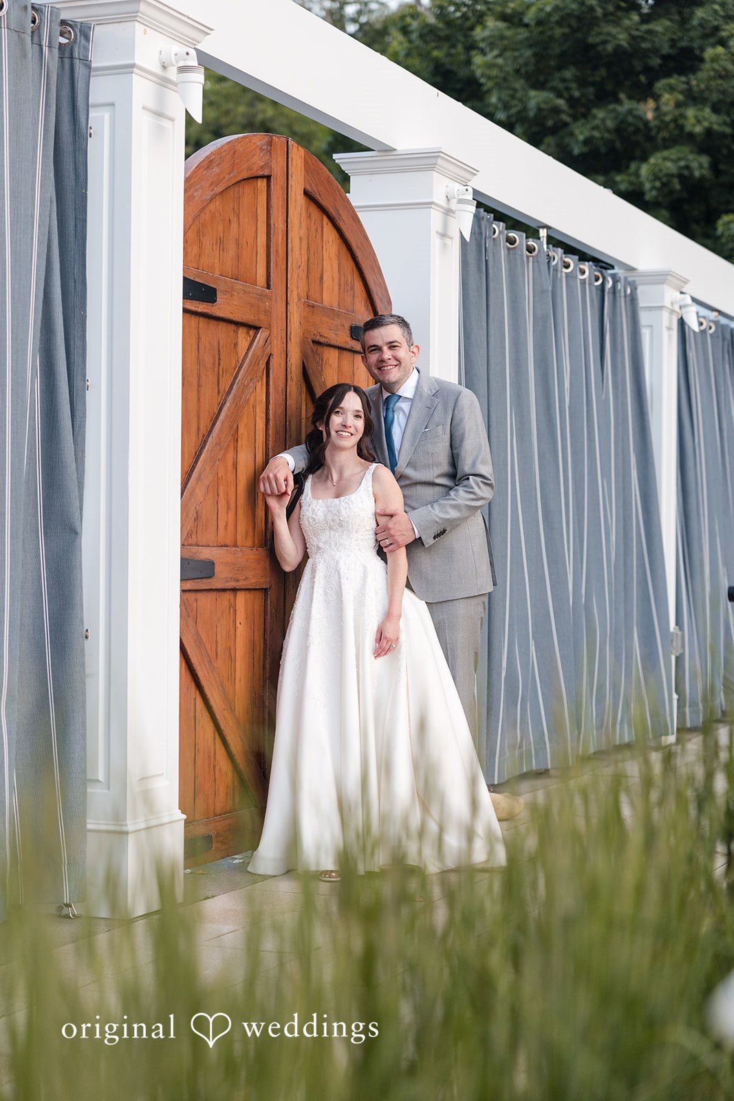 Kerri + David Bride and groom posing beside the rustic wooden door at Oceanview of Nahant