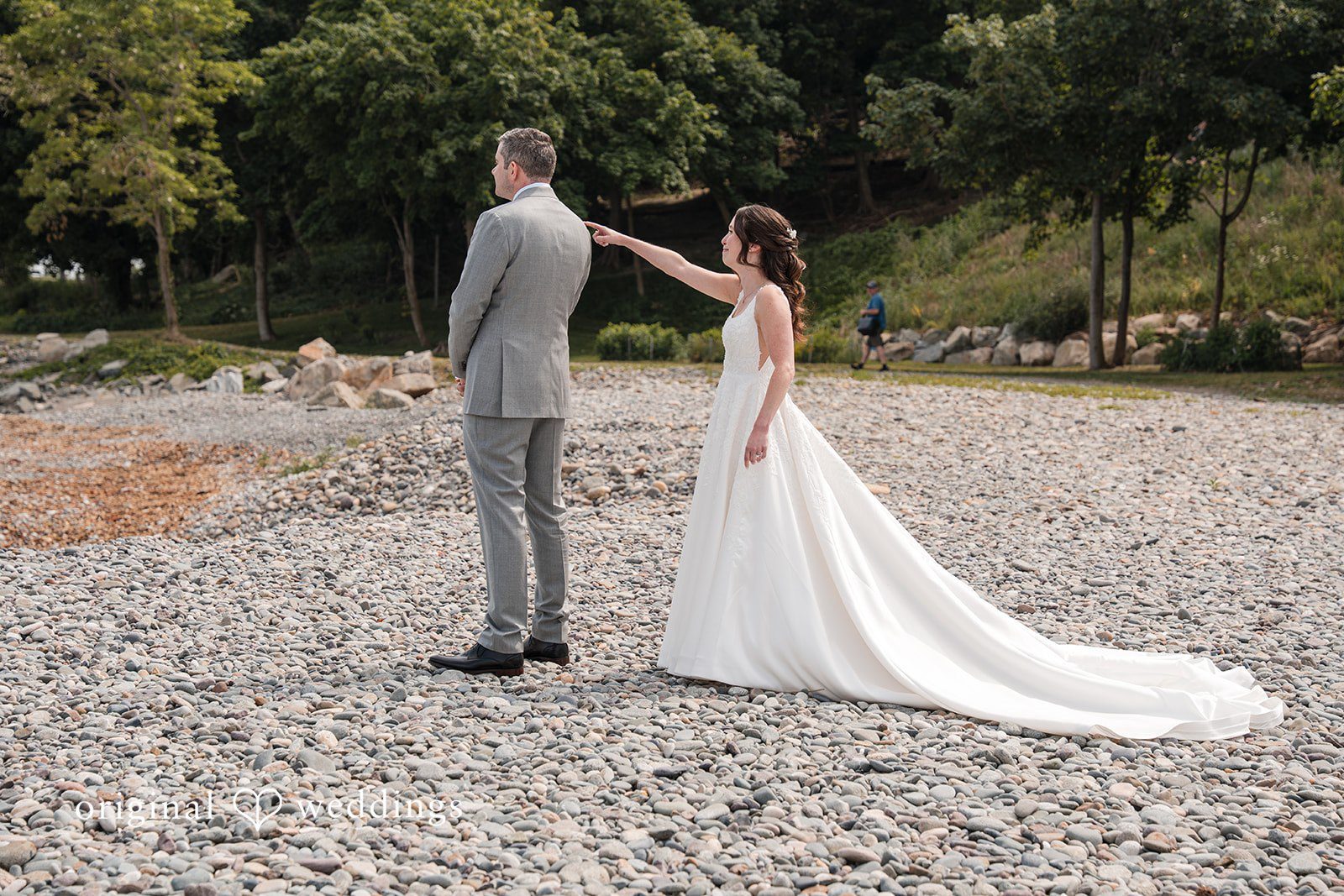 Kerri + David Bride pointing toward the ocean during a playful first look at Oceanview of Nahant captured by Boston Wedding Photographers from Original Weddings.