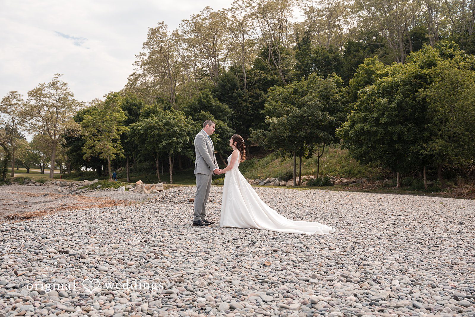 Kerri + David Bride and groom holding hands on the beach at Oceanview of Nahant captured by Boston Wedding Photographers from Original Weddings