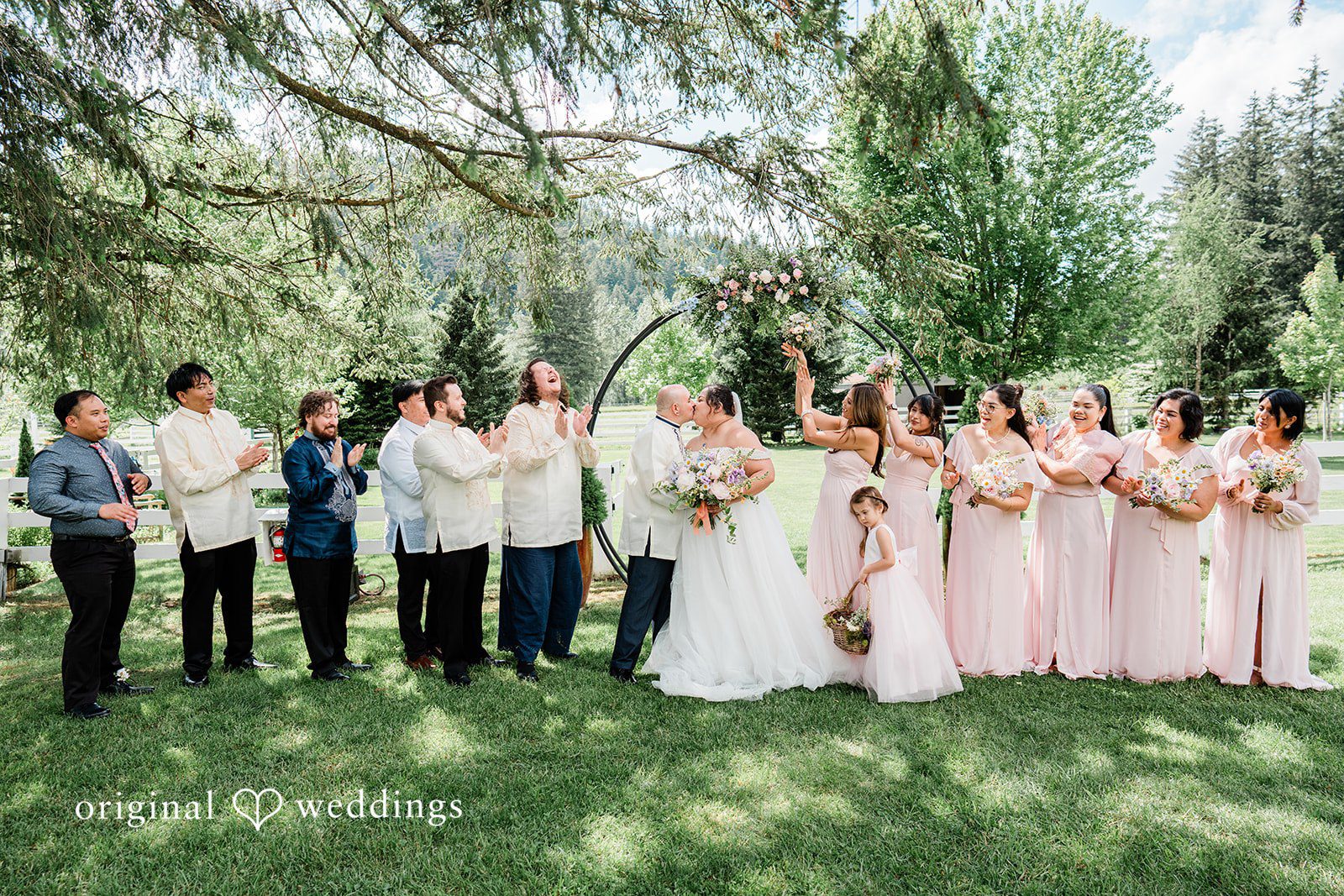 Tiffany Hazel + Ryan The couple takes a romantic kiss with cheers from their bridal party