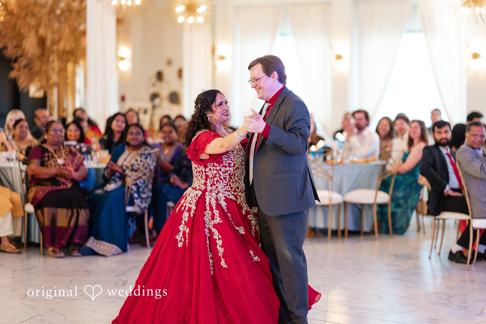 Anthony + Simi A groom and a bride dancing together in front of wedding guests.