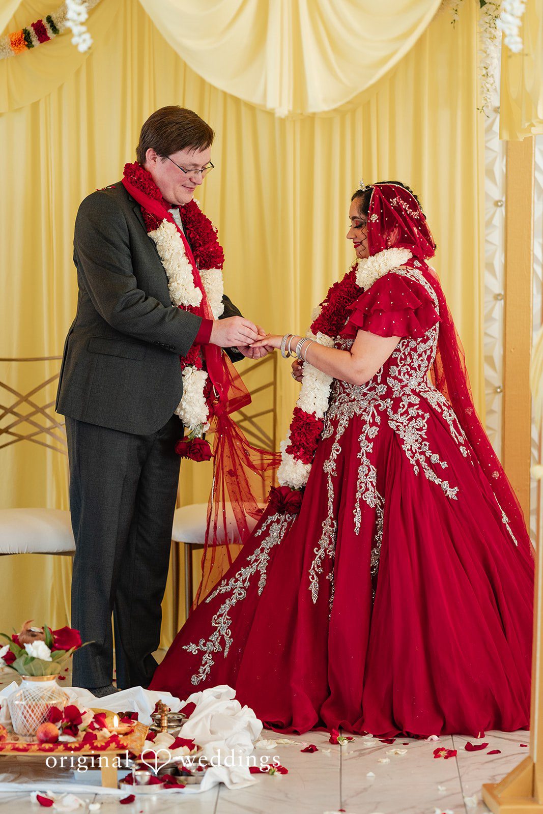 Anthony + Simi A bride and groom standing together and exchanging rings.