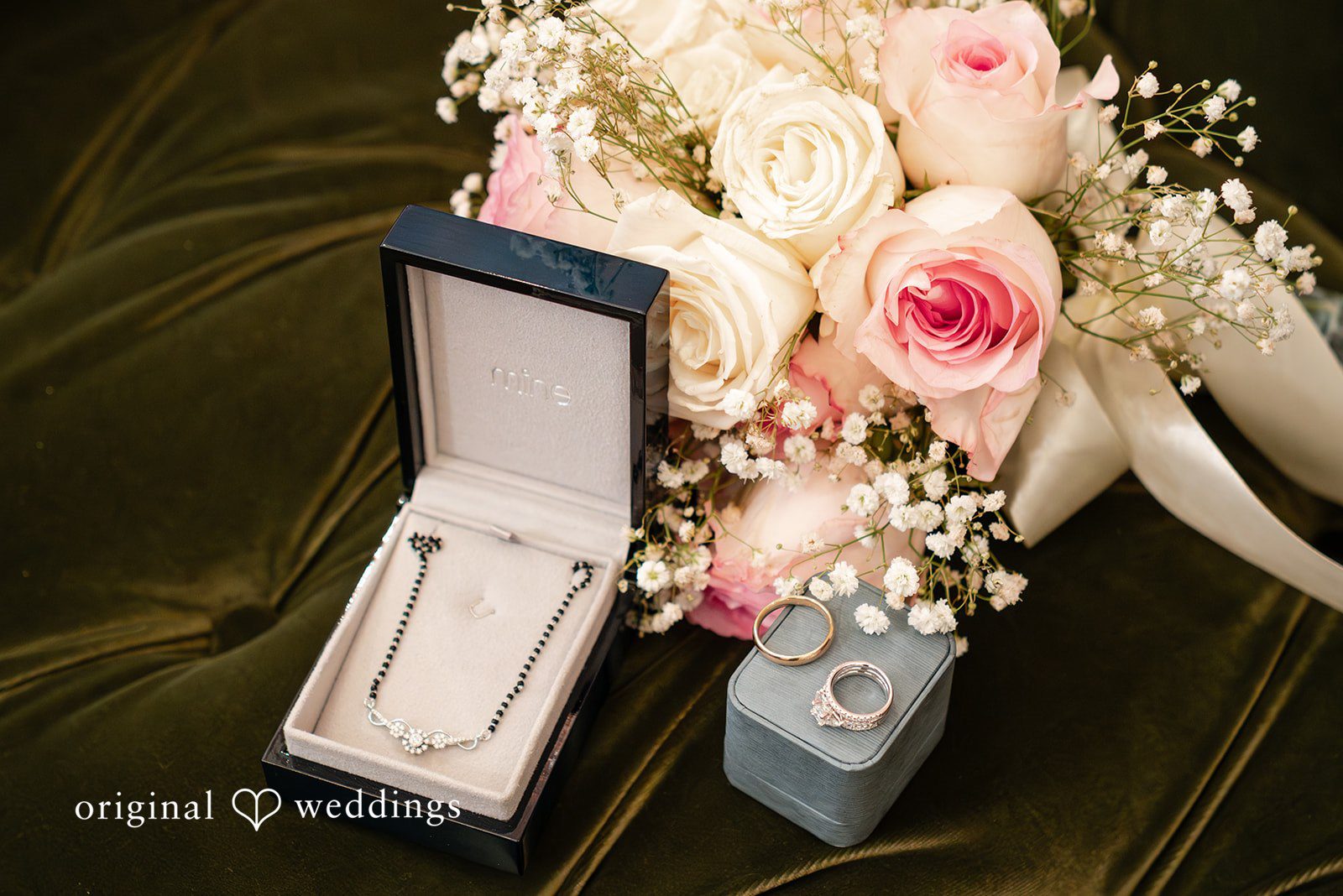 Anthony + Simi Wedding jewelry boxes placed next to a bouquet of pink roses.