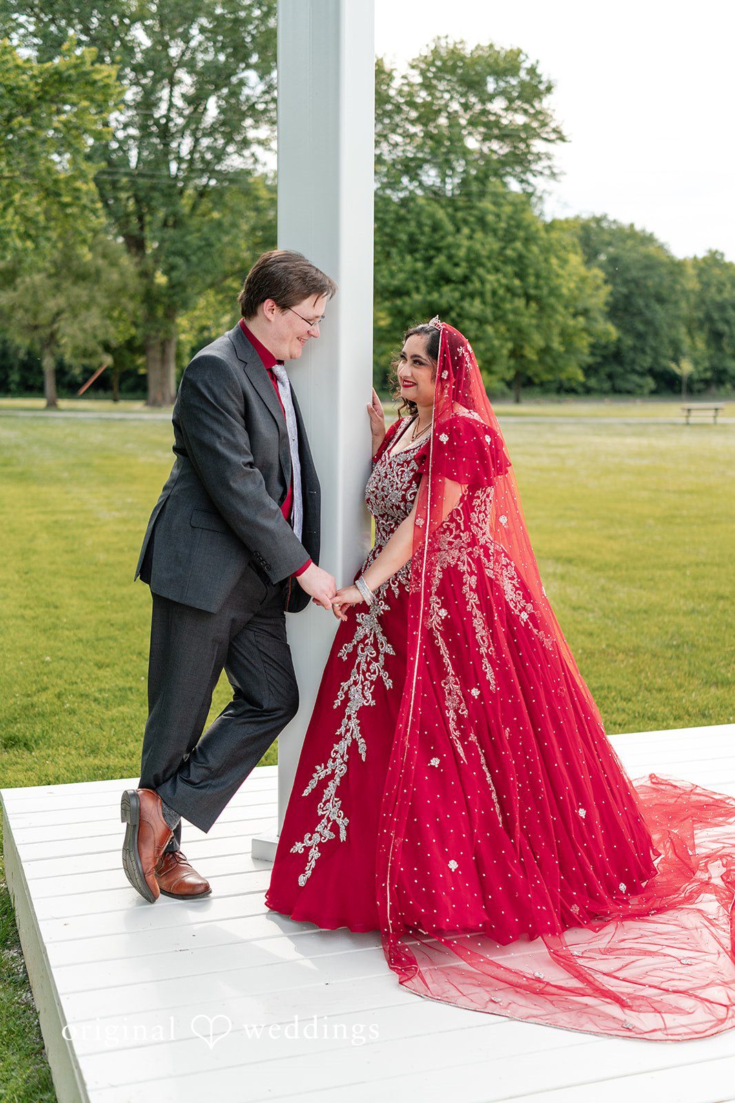 Anthony + Simi A bride and groom holding hands while facing each other.