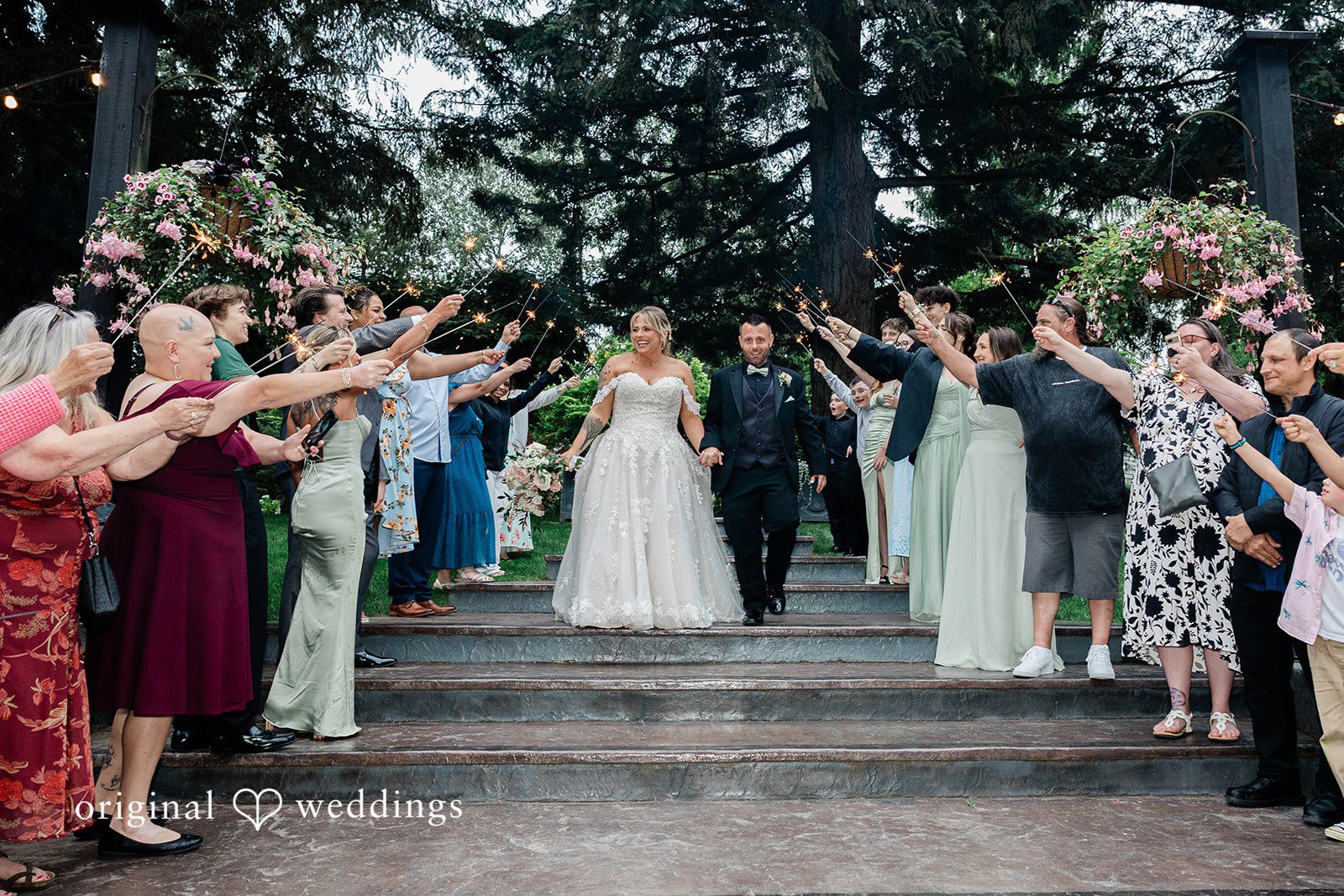 AlyssaMay + Benjamin Bride and groom walking hands in hands through the guests cheering around
