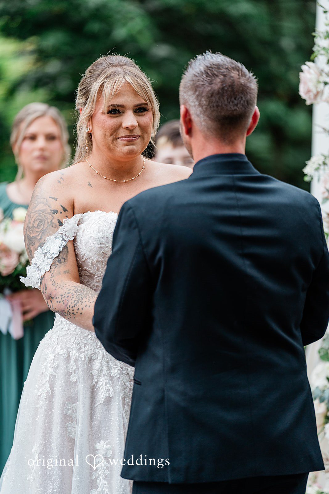 AlyssaMay + Benjamin Bride looking at the groom with a smile during wedding ceremony at Rock Creek Gardens captured by Seattle wedding photographers from Original Weddings