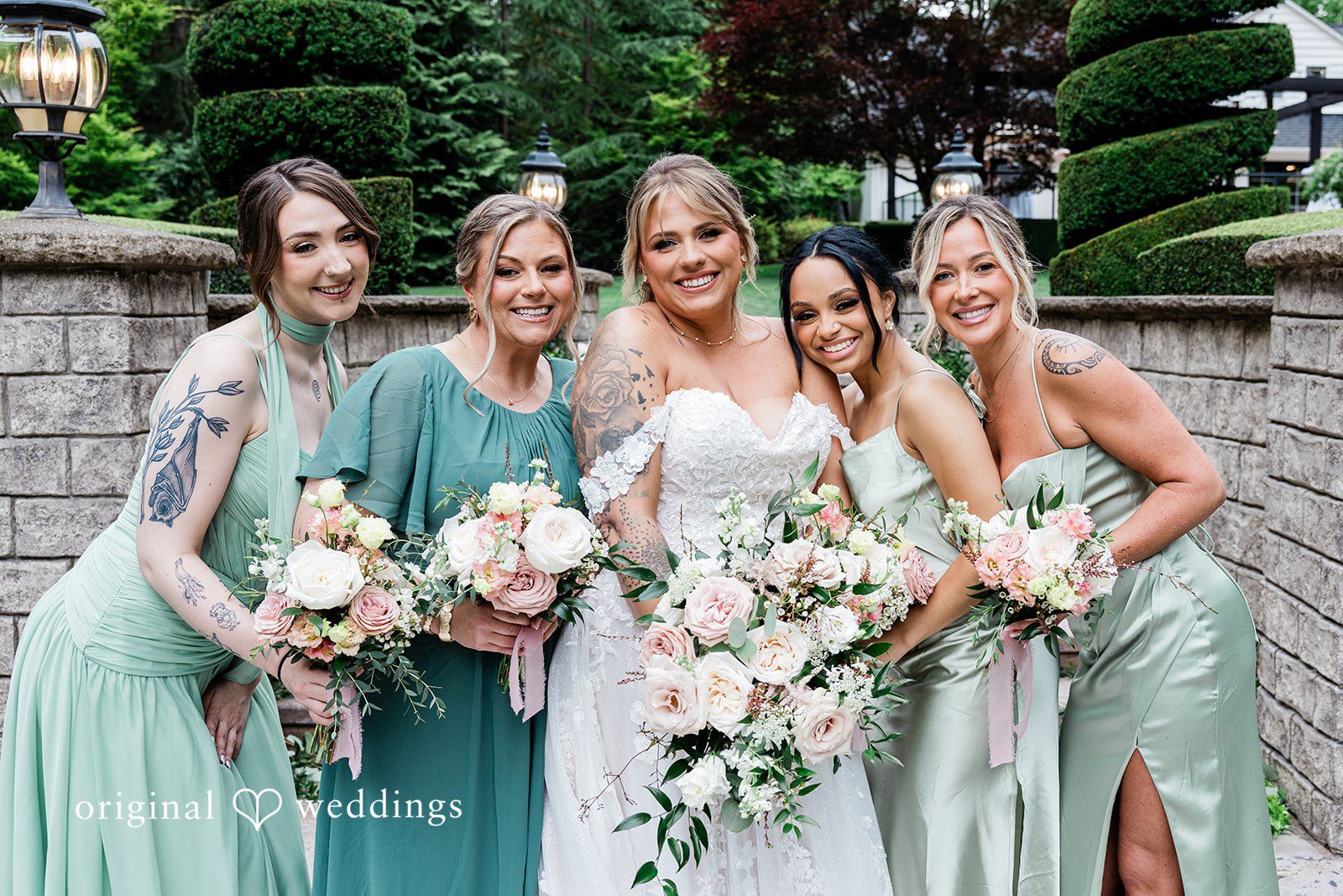 AlyssaMay + Benjamin Group photo of bride with bridesmaids, all smiling and holding bouquets