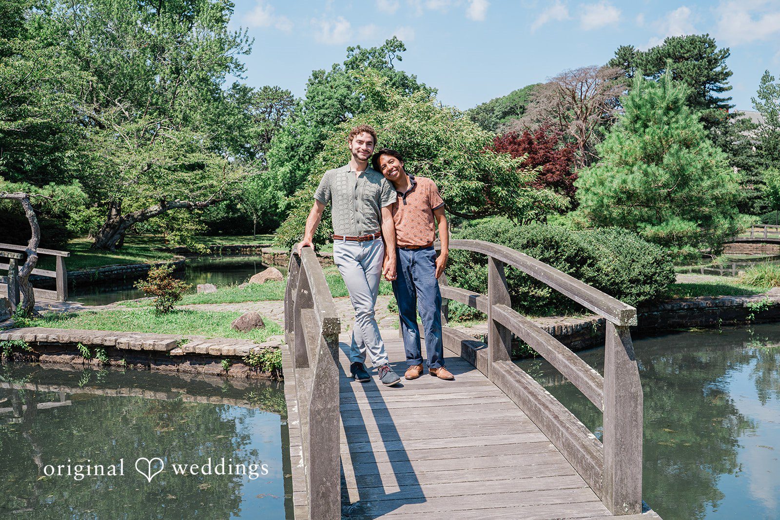 Couple standing by water while holding hands  at Roger Williams Park