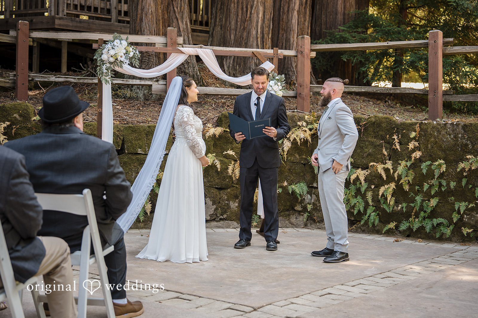 Brittany + Shane Couple standing before the priest while looking at each other at Sanborn County Park