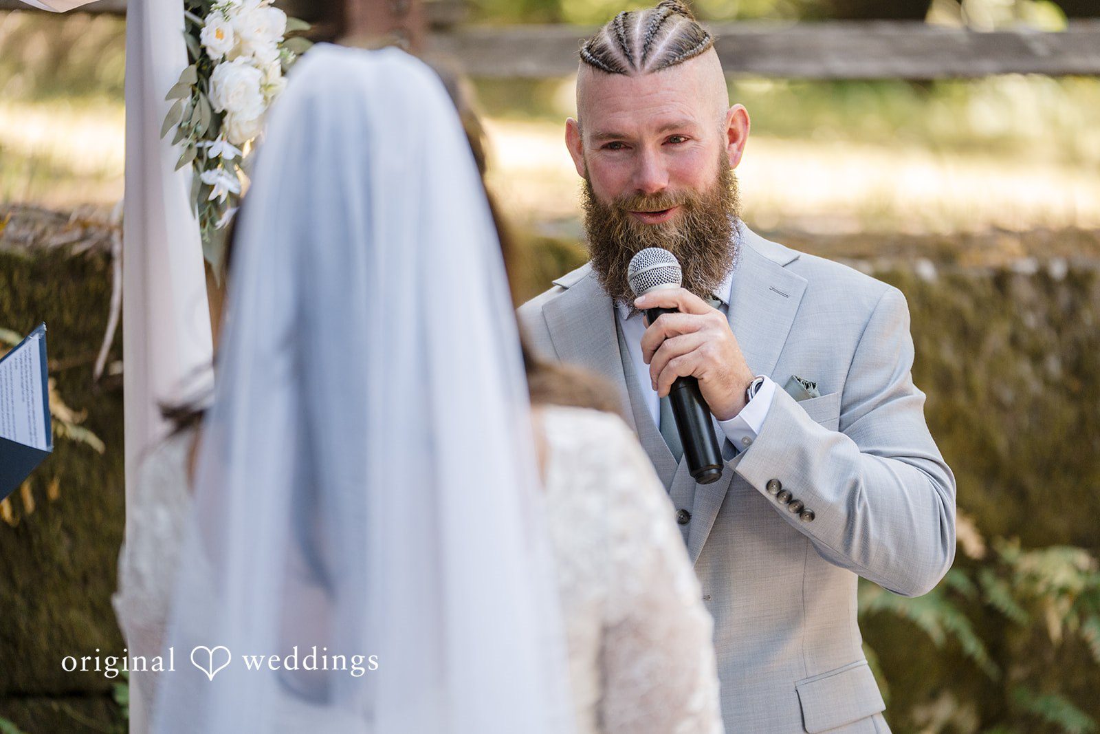 Brittany + Shane Groom holding a microphone while looking at the bride at Sanborn County Park