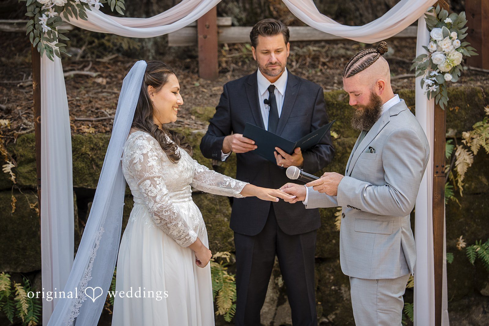 Brittany + Shane Groom placing the ring on the bride's finger during the ceremony at Sanborn County Park