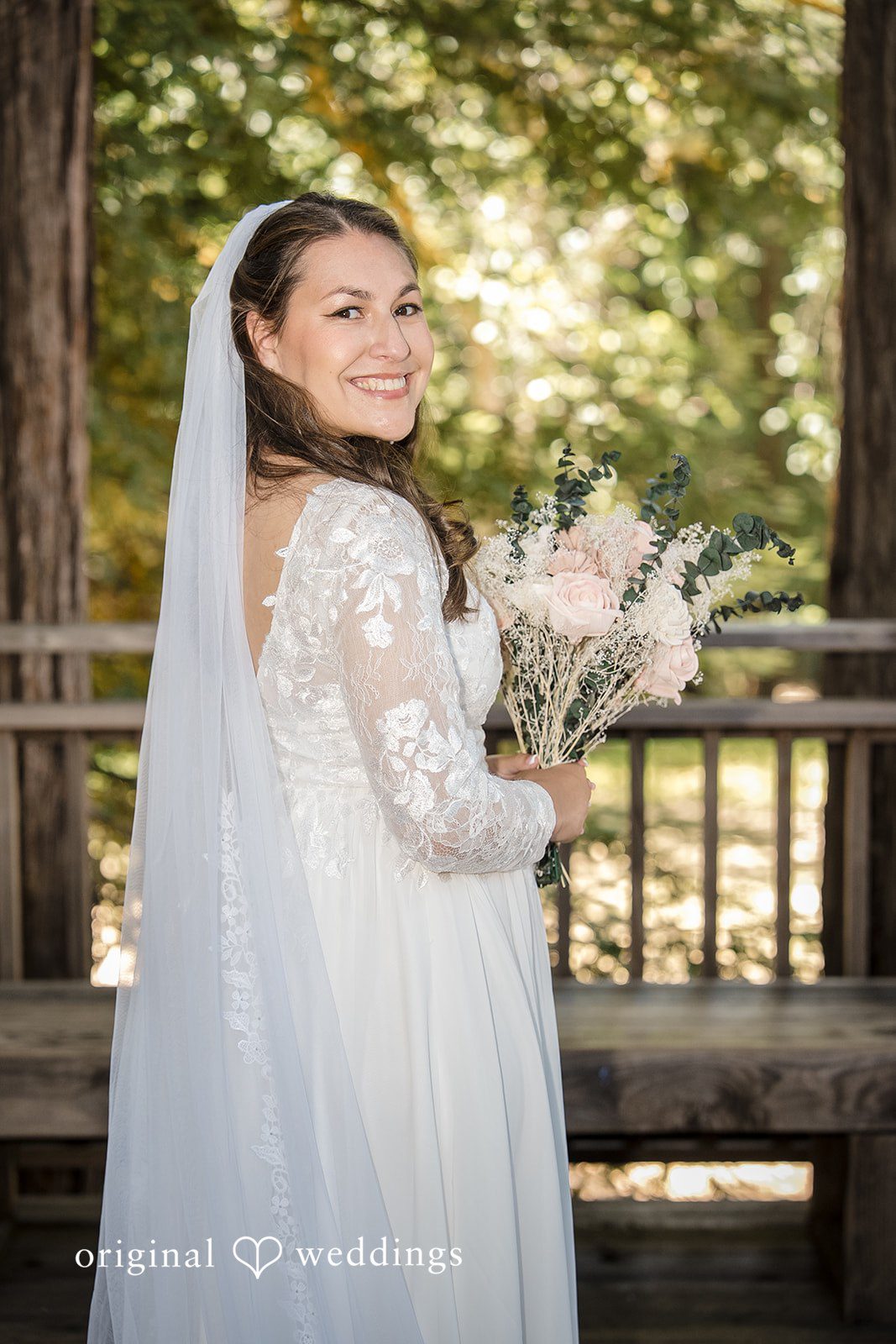 Brittany + Shane Elegant bride smiling with flowers at Sanborn County Park