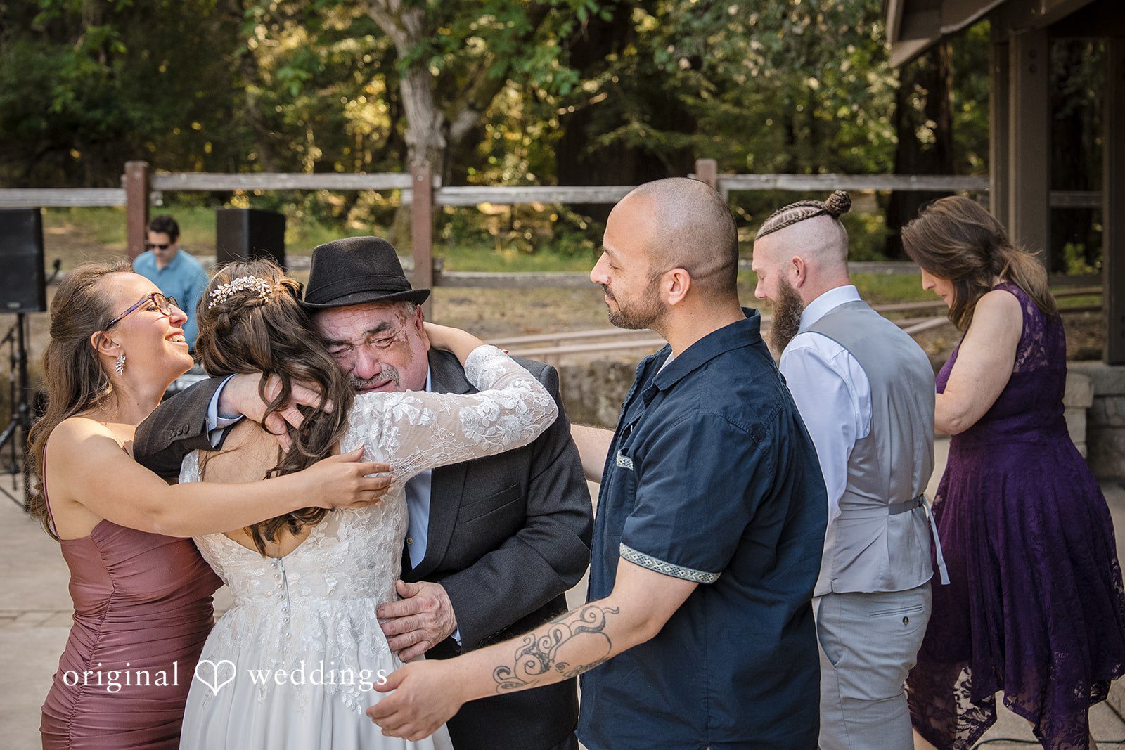 Brittany + Shane Bride emotionally hugging someone while the groom stands beside her at Sanborn County Park