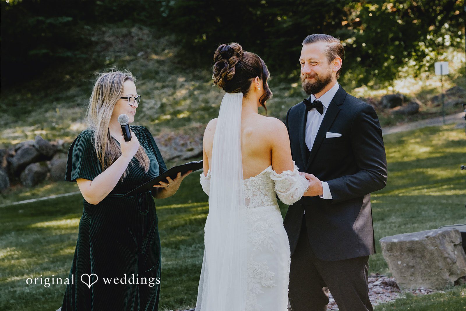 Kristina + Christopher Bride and groom holding hands during their wedding ceremony with an officiant.
