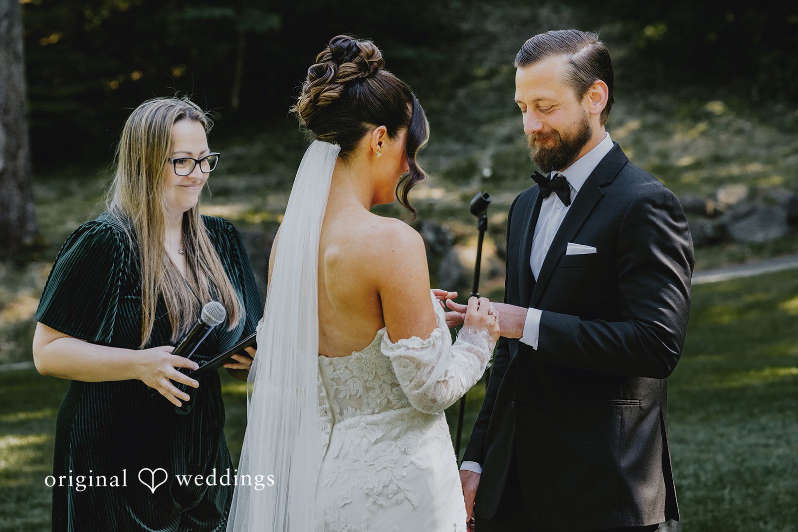 Kristina + Christopher Bride placing a wedding ring on the groom's finger.