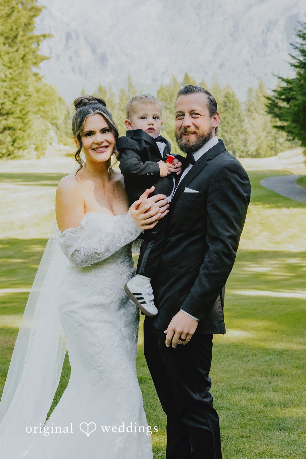 Kristina + Christopher The bride and groom posing for a photo with a child.