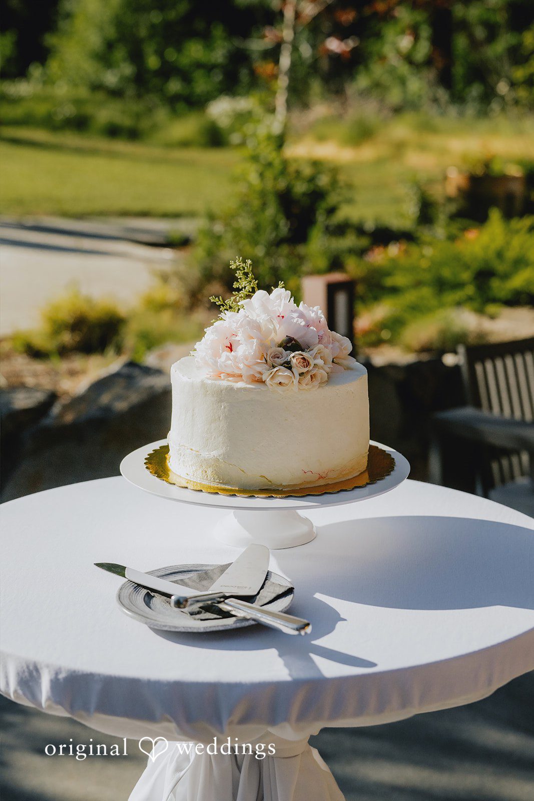 Kristina + Christopher Single-tier white frosted wedding cake resting on a pedestal table.