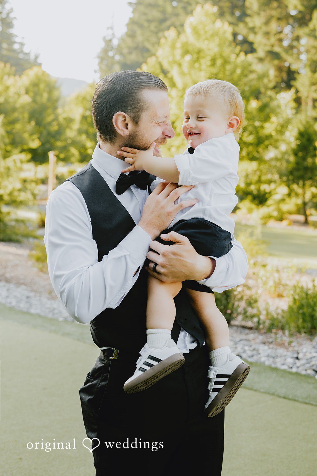 Kristina + Christopher A groom smiling during a moment with a child at the wedding.