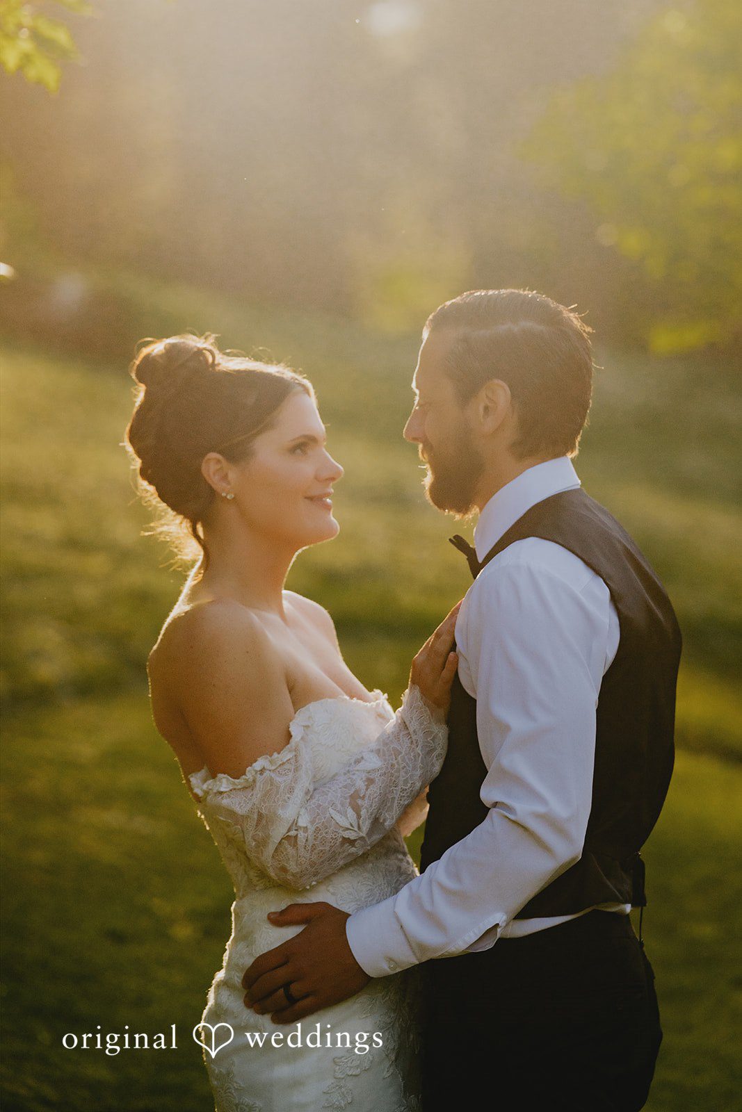 Kristina + Christopher Bride and groom embracing and looking at each other in sunlight.