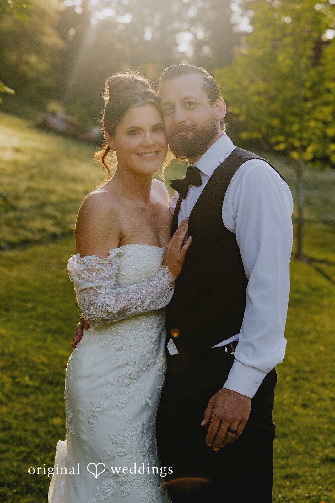 Kristina + Christopher Smiling bride and groom posing closely together in a wooded setting.