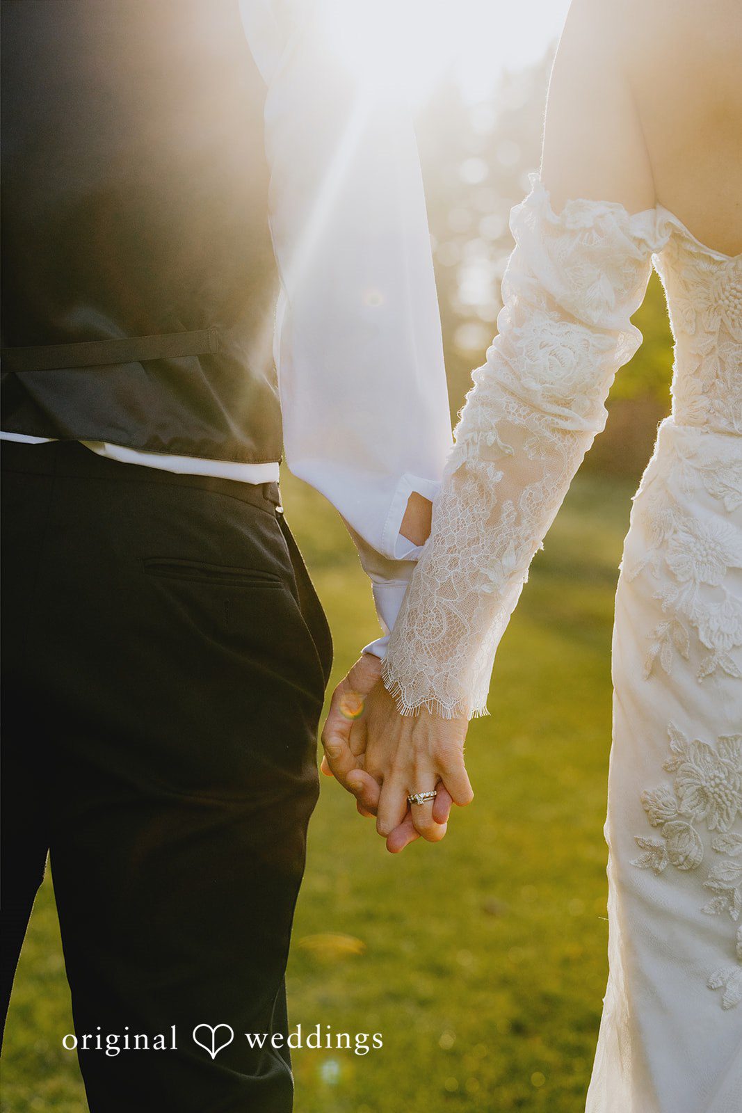 Kristina + Christopher Close-up of the bride and groom holding hands while walking.