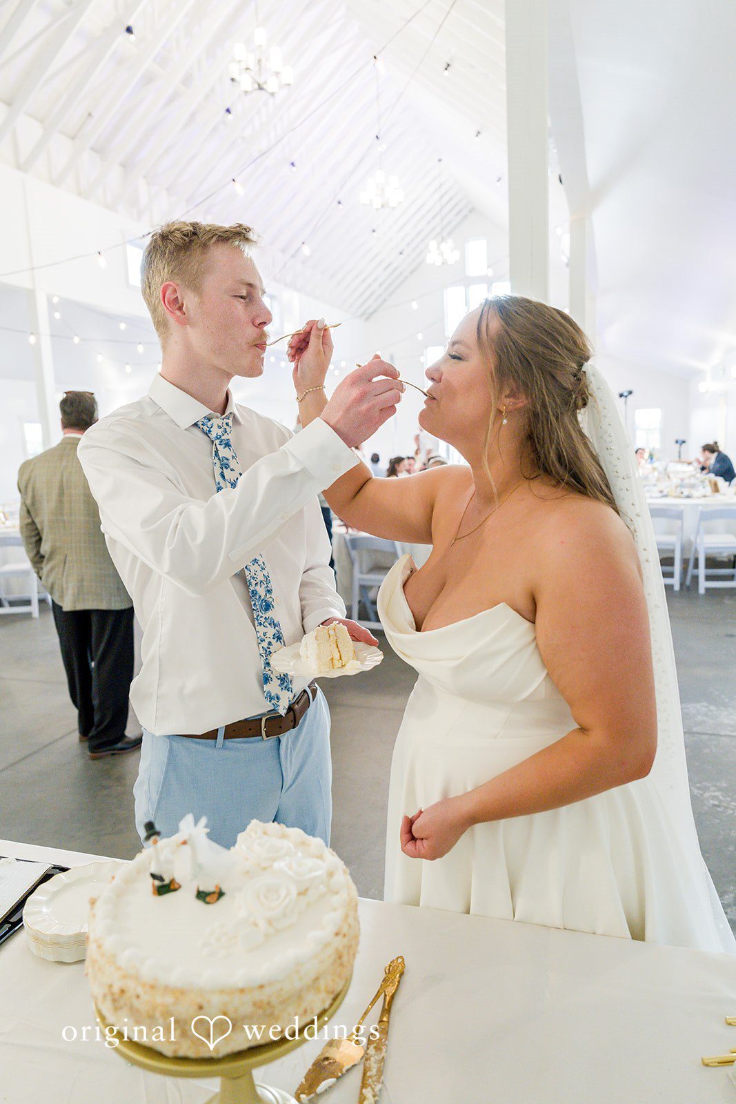 Emily + Ridge Bride and groom feeding wedding cake at Spruce Hill.
