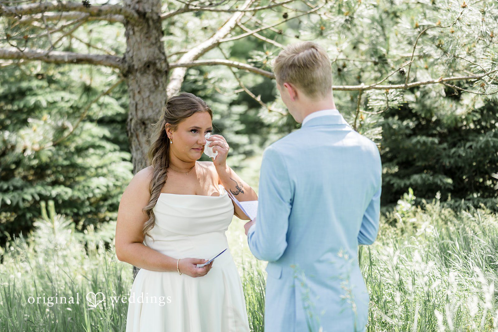 Emily + Ridge Emotional moment as Bride and groom sharing heartfelt note beneath the trees at Spruce Hill.