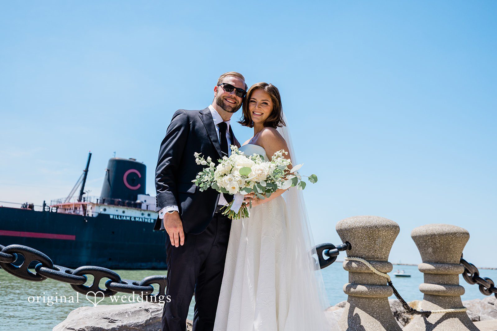 Luke + Madison Bride and groom smiling by the waterfront at St. Clair Ballroom captured by Cleveland Wedding Photographers from Original Weddings.