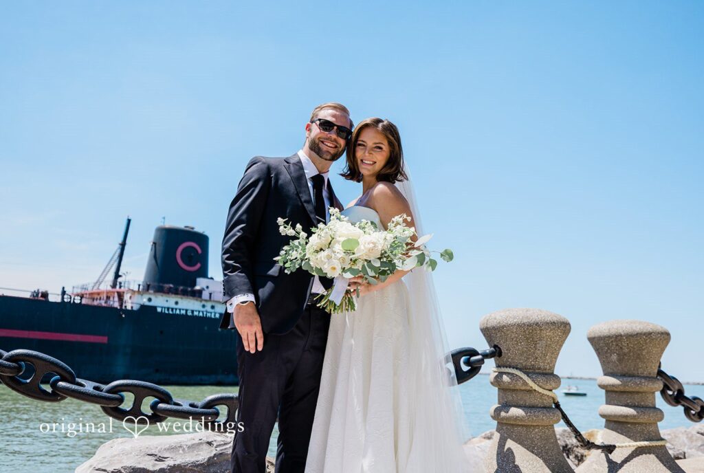 Bride and groom smiling by the waterfront at St. Clair Ballroom captured by Cleveland Wedding Photographers from Original Weddings.