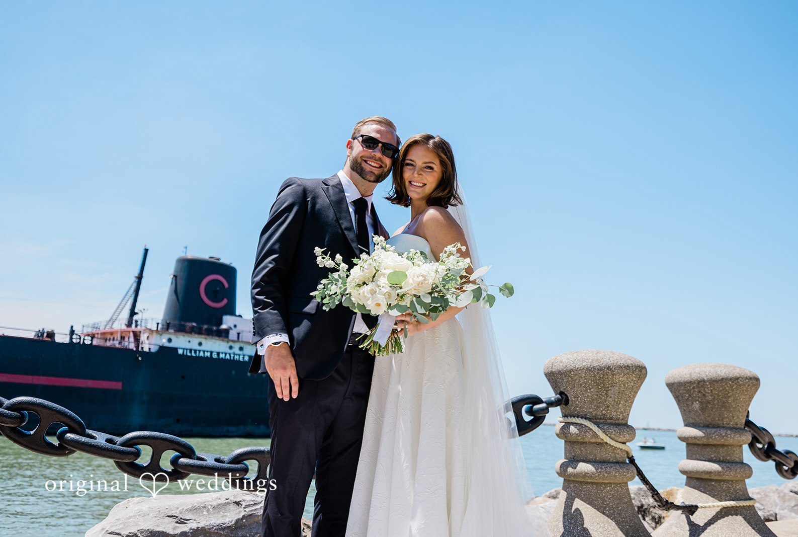 Bride and groom smiling by the waterfront at St. Clair Ballroom captured by Cleveland Wedding Photographers from Original Weddings.