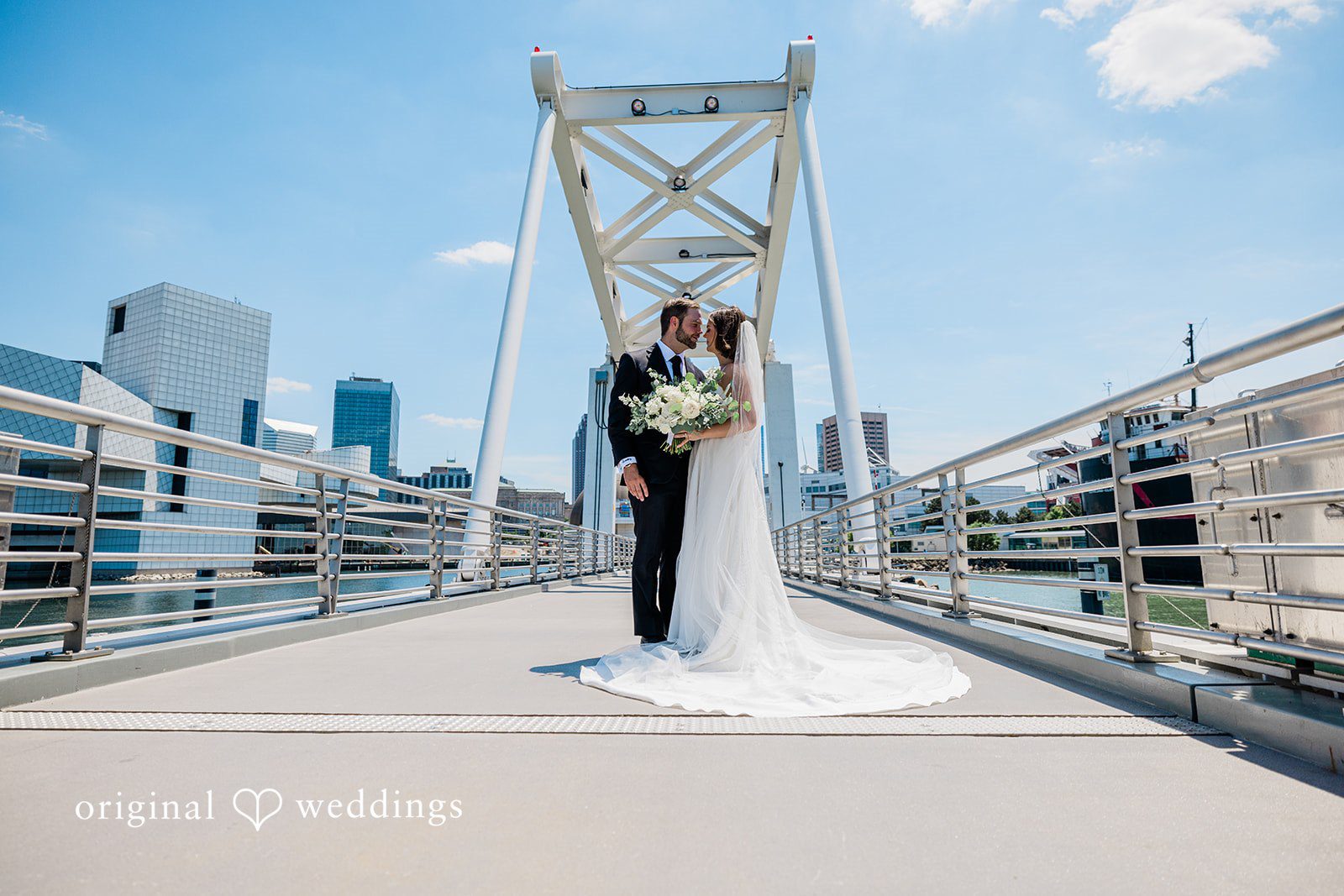 Luke + Madison Elegant couple portrait on a waterfront bridge near at St. Clair Ballroom captured by Cleveland Wedding Photographers from Original Weddings.