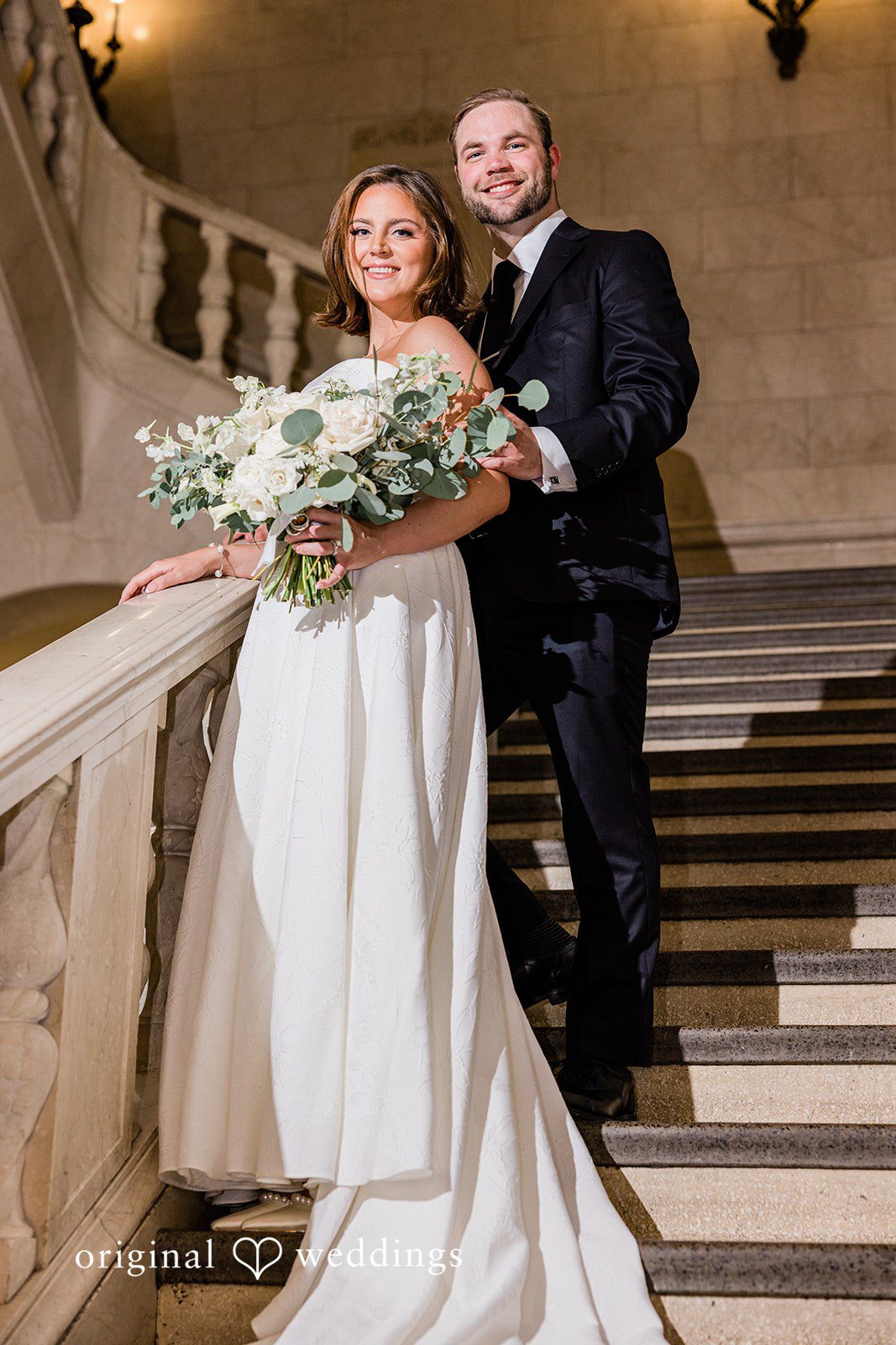 Luke + Madison Bride and groom smiling together on the elegant staircase at St. Clair Ballroom.